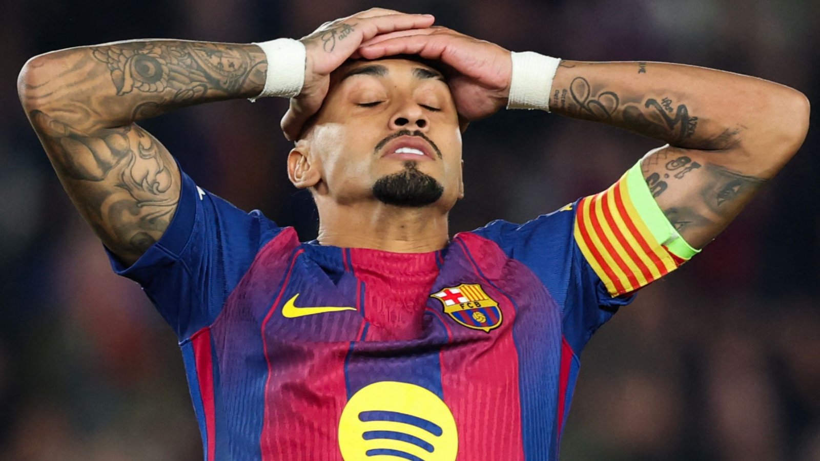 Raphinha, portant le brassard de capitaine du Barcelone, réagit avec frustration après un moment controversé lors d'un match.