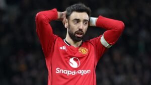 Bruno Fernandes en tenue rouge de Manchester United, visiblement frustré pendant un match, portant le brassard de capitaine.