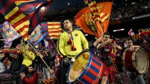 Barcelona-fans vieren gepassioneerd met vlaggen en trommels tijdens een wedstrijd in Camp Nou, waarbij ze hun teamgeest en levendige kleuren tonen.