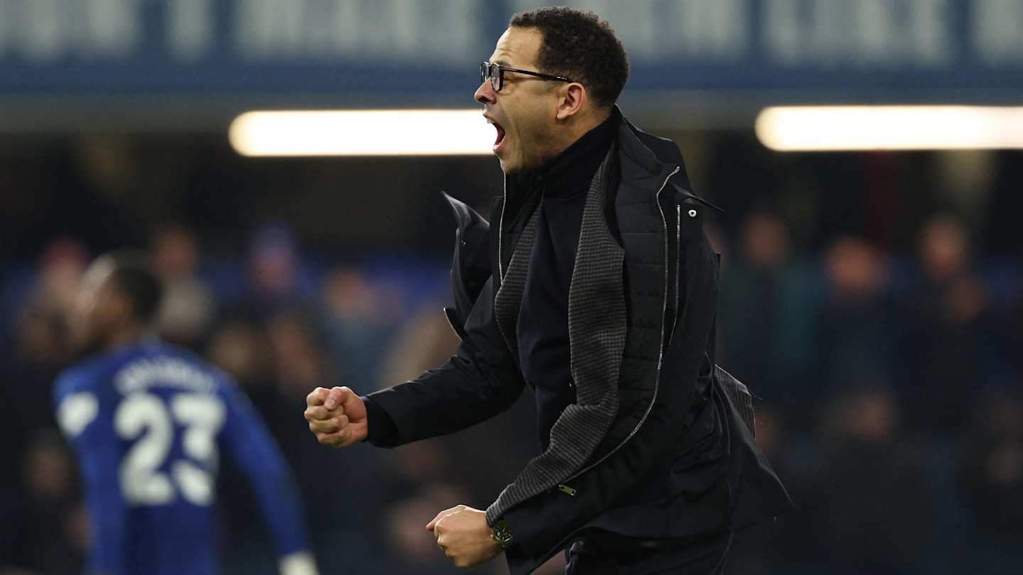 Chelsea's manager celebrates passionately on the sidelines during a match, showing determination and excitement for his team's performance.