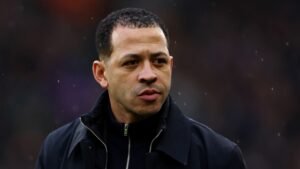 Liam Rosenior, l'entraîneur de Chelsea en veste noire, observe pensivement depuis la touche lors d'un match contre Arsenal.