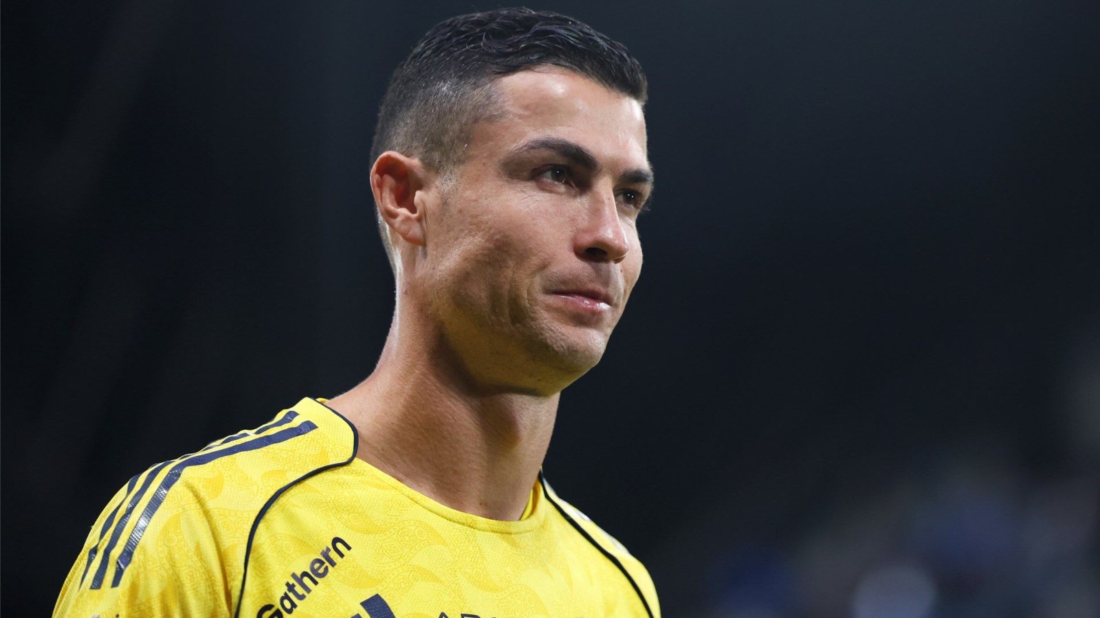 Cristiano Ronaldo in a yellow Al Nassr kit, looking determined during a match, highlighting his commitment to the team.