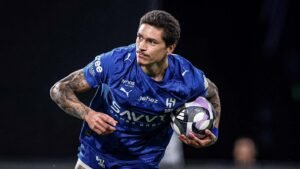 Darwin Núñez in a blue football kit, preparing to make a play during a match, showcasing his intensity and focus on the field.