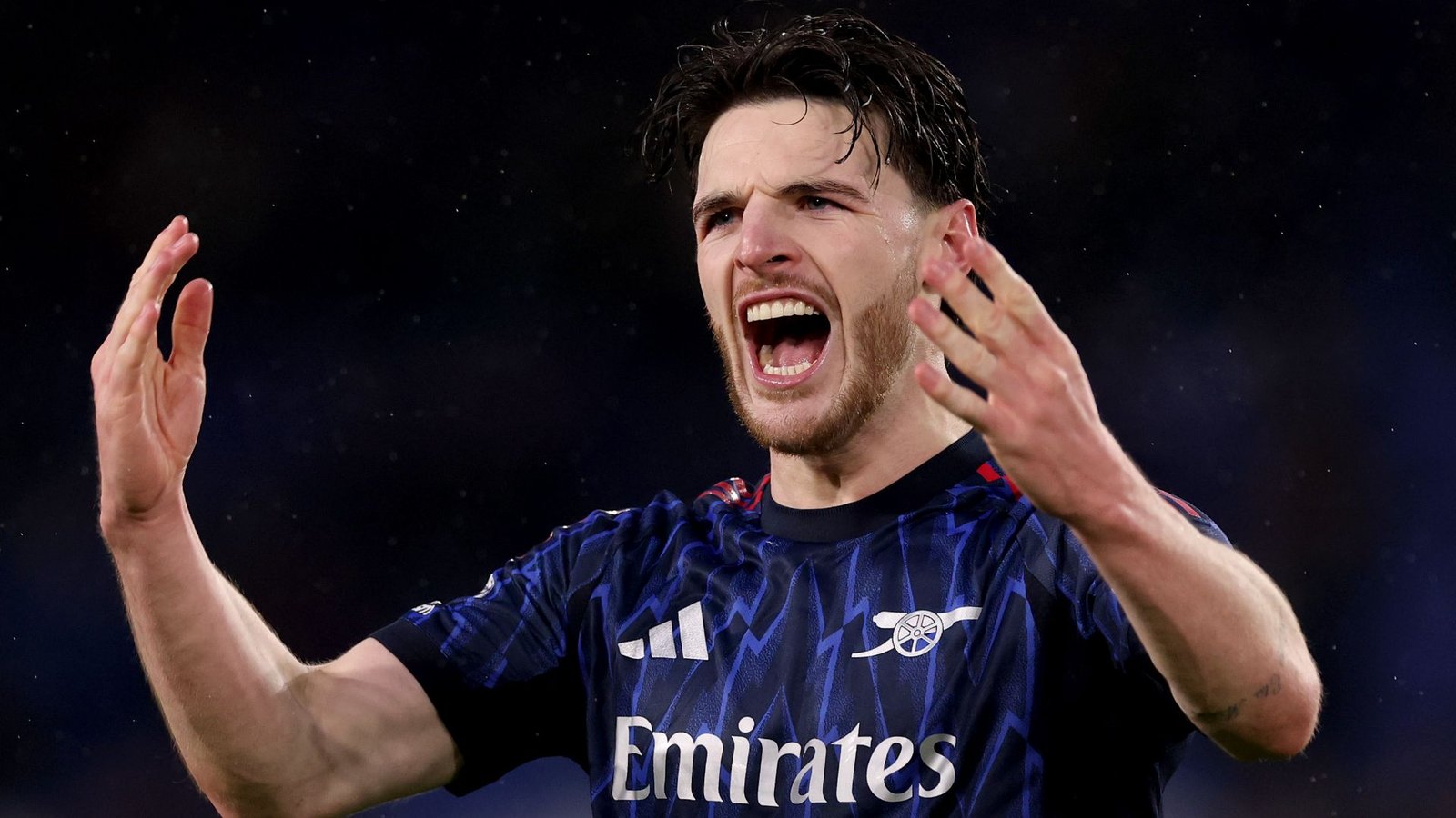 Declan Rice célèbre avec passion dans le maillot extérieur bleu d’Arsenal, faisant preuve de détermination et de leadership sur le terrain.