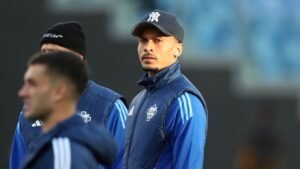 Dele Alli en tenue d'entraînement pour un match, l'air concentré, avec des coéquipiers en arrière-plan ; illustrant son retour à son ancien club.