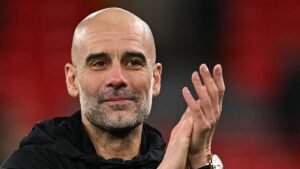 Pep Guardiola sourit et applaudit, réfléchissant à la récente victoire de Manchester City sur Liverpool, faisant preuve de confiance et de leadership.