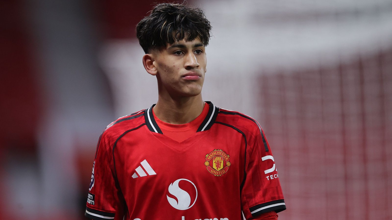 Gabriel, wearing Manchester United's red home kit, stands focused during first-team training at Old Trafford.