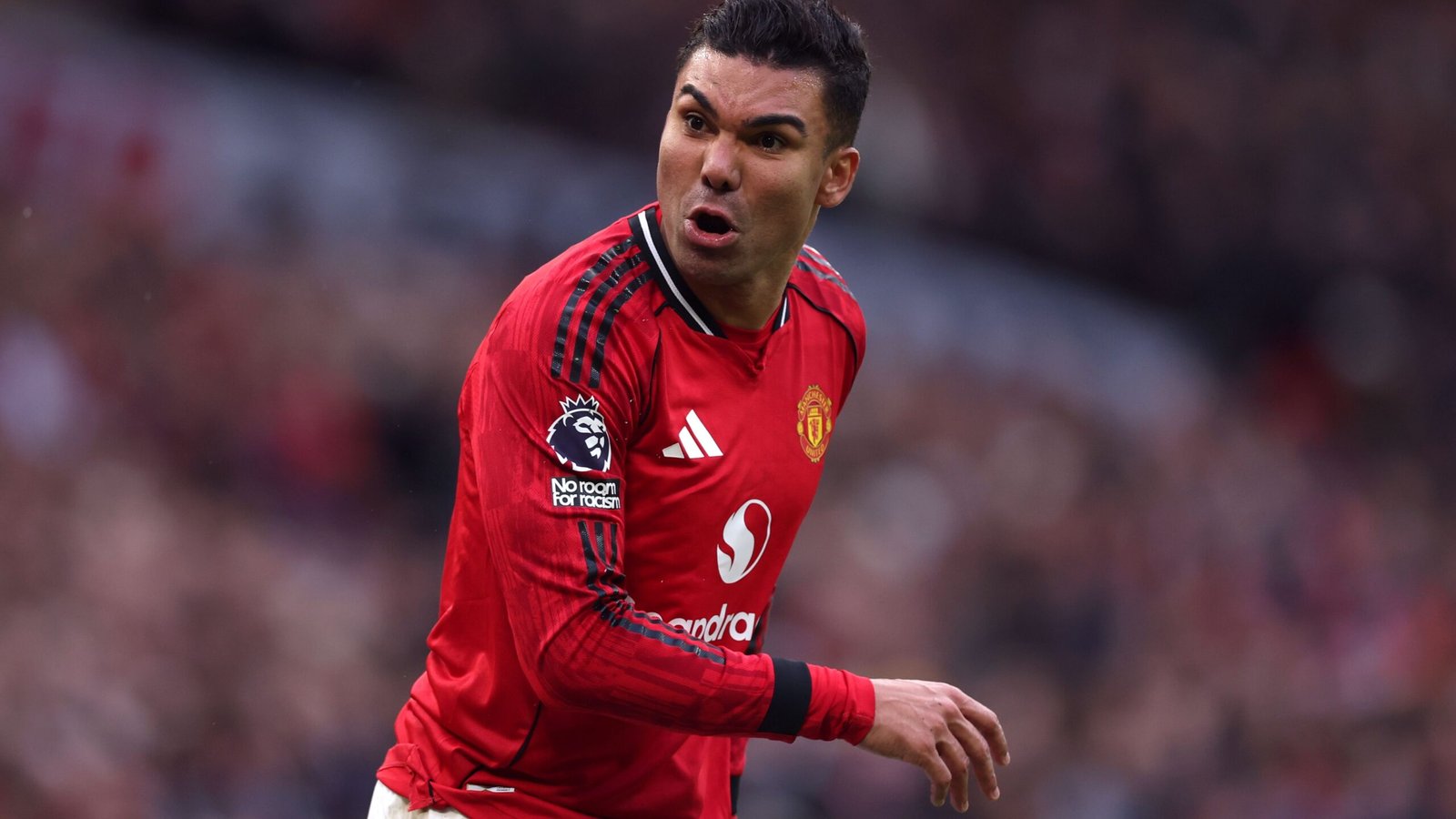 Casemiro portant le maillot rouge de Manchester United, célébrant avec passion pendant un match, montrant des émotions intenses et un esprit d'équipe.