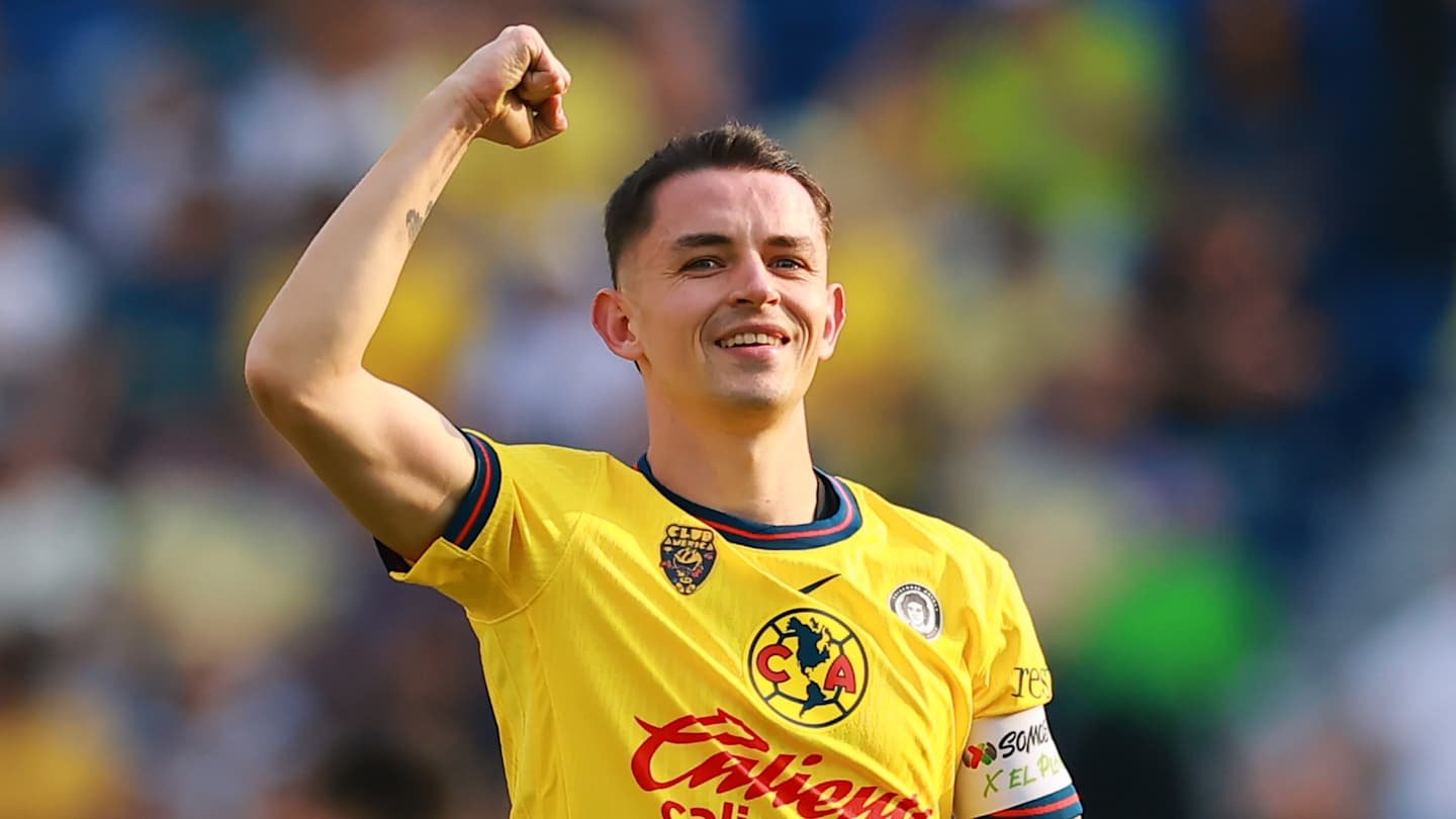 Celebrating player in a yellow América jersey, fist raised in triumph, showcasing excitement during a Liga MX match.