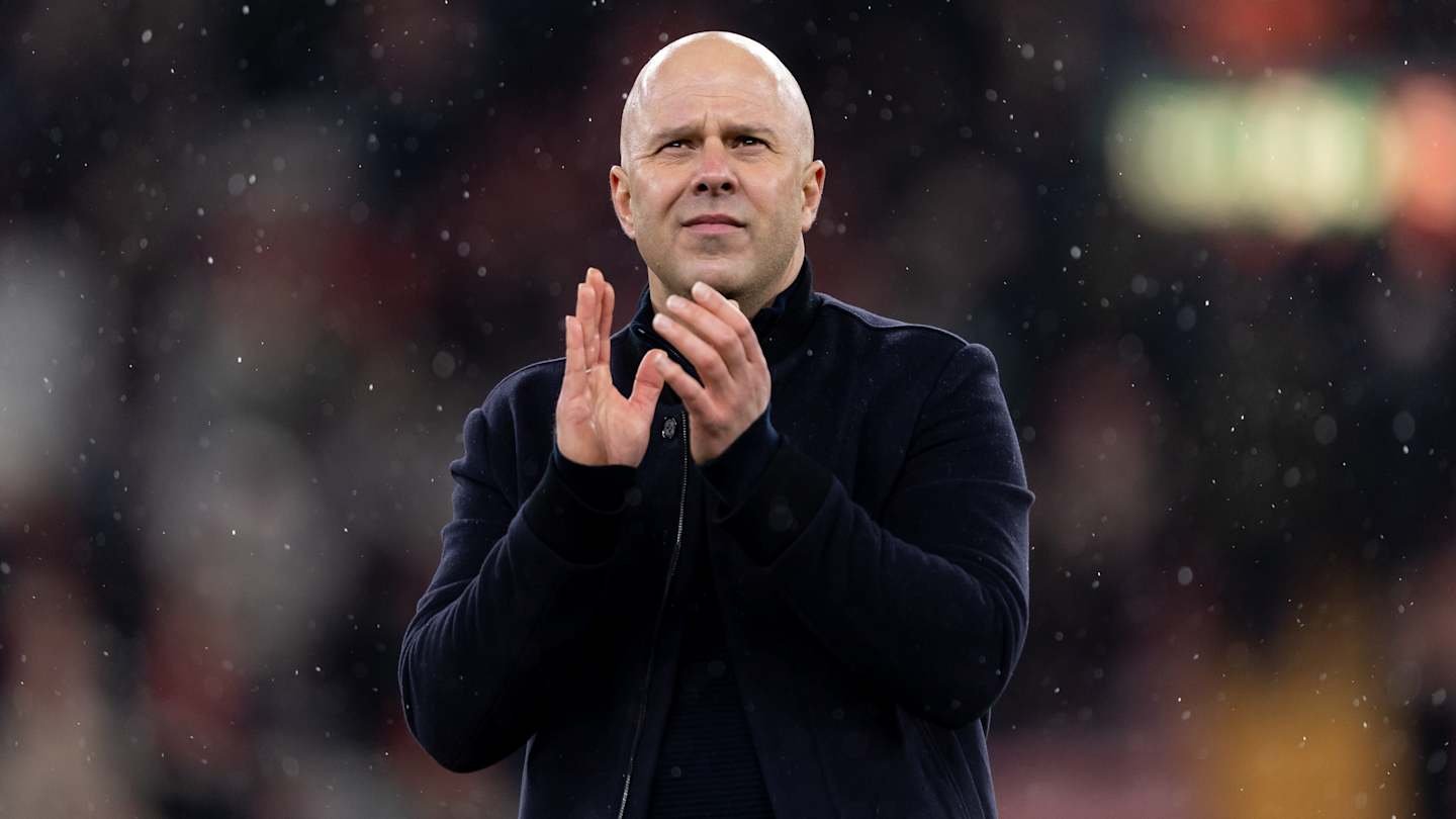 Manager applauding fans in the rain, highlighting the emotional connection between the team and supporters during a match.