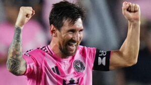 Lionel Messi célèbre dans un maillot rose de l'Inter Miami, levant les poings en signe de victoire lors d'un match, montrant ainsi sa joie et son enthousiasme.