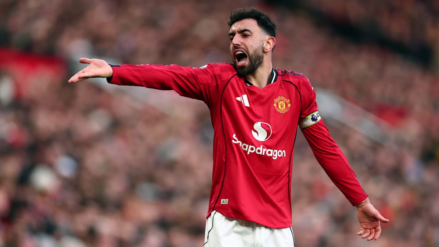 Bruno Fernandes, wearing Manchester United's red kit and captain's armband, passionately gestures during a match at Old Trafford.