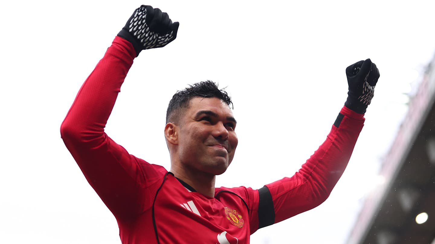 Casemiro in Manchester United's home kit, celebrating with raised arms, showcasing determination and team spirit during a match.