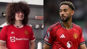 Manchester United fan with curly hair reacts playfully next to Matheus Cunha in the club's red kit during a match.
