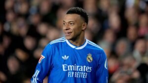 Kylian Mbappé in a blue Real Madrid training kit, smiling during a session ahead of the match against Real Sociedad.