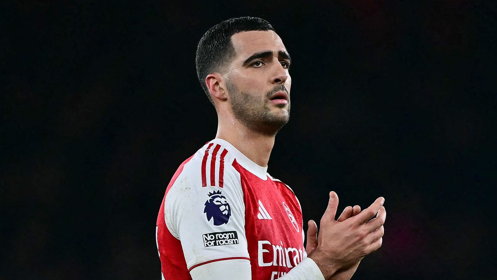 Mikel Merino vêtu du maillot rouge d'Arsenal, affichant une expression réfléchie pendant un match, soulignant sa concentration et sa détermination.