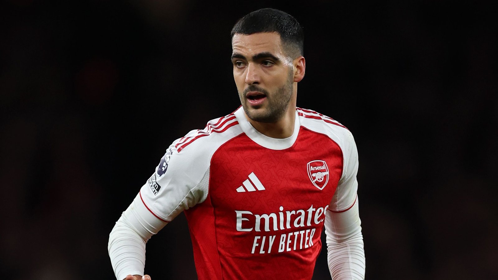 Mikel Merino wearing Arsenal's red and white kit during a Premier League match, showcasing determination on the pitch.