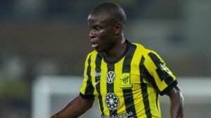 N’Golo Kanté in a black and yellow striped kit, representing Ittihad FC, during a match, showcasing his dynamic playing style.