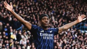 Noni Madueke viert met uitgestrekte armen na zijn doelpunt voor Arsenal tegen Leeds in een levendige uitwedstrijd.