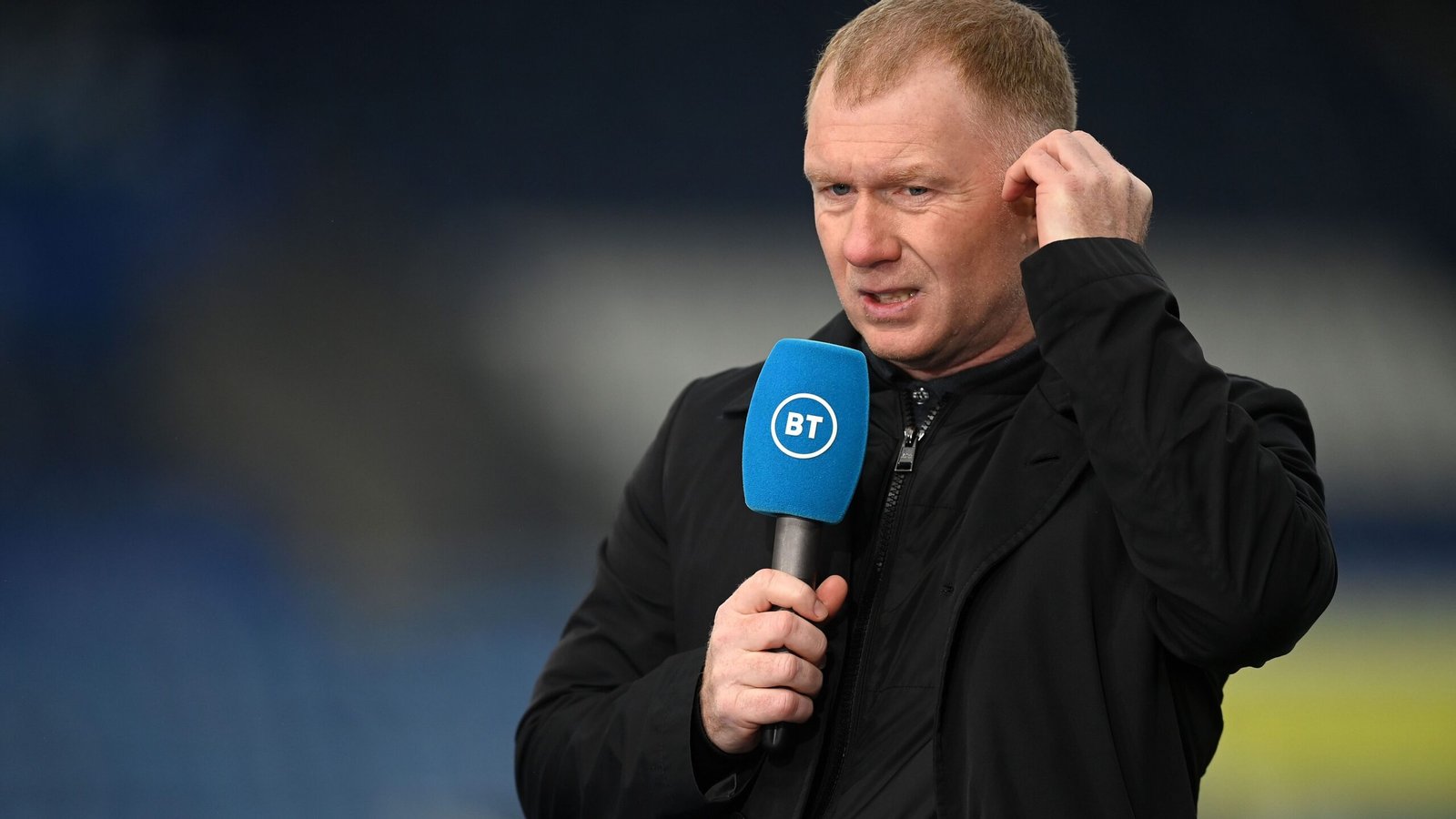 Paul Scholes, vêtu d'une veste noire, parlant dans un micro de BT Sport pour une analyse post-match.