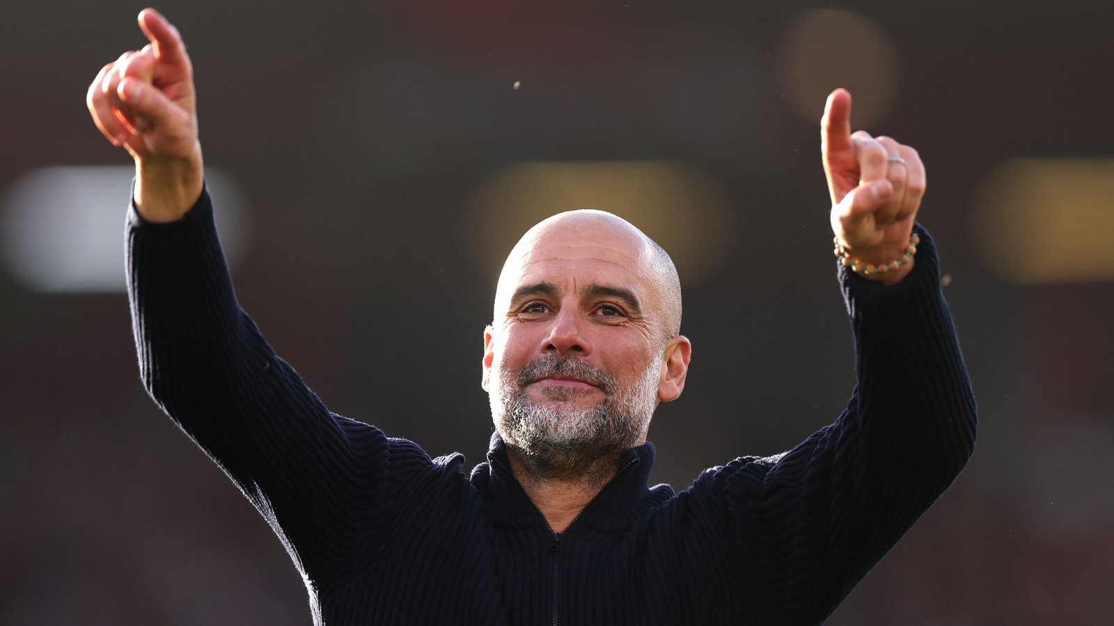 Pep Guardiola gestures in celebration, smiling as he expresses his enthusiasm for the FA Cup ahead of the Salford clash.