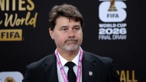 Mauricio Pochettino, vêtu d'un costume-cravate noir, assistant au tirage au sort de la Coupe du Monde FIFA 2026, affichant une expression sérieuse.
