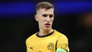 Borussia Dortmund player in yellow kit with club crest, displaying a focused expression during a match.