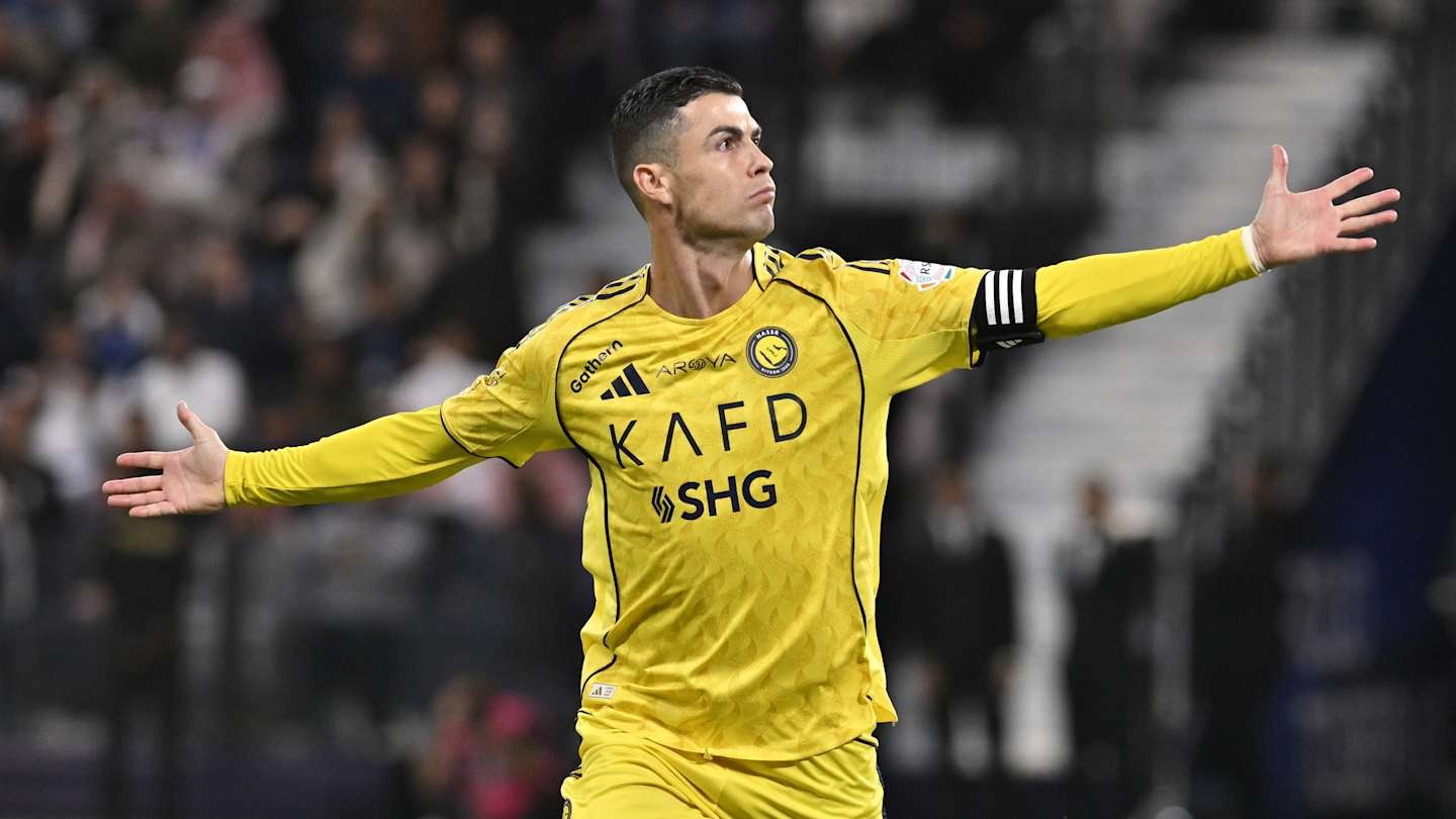 Cristiano Ronaldo celebrating in Al Nassr's yellow kit with arms outstretched, showcasing his confidence during a match.