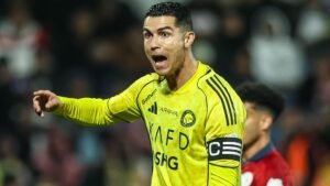 Cristiano Ronaldo en tenue jaune d'Al Nassr, gesticulant avec passion lors d'un match contre Al Ittihad, démontrant son leadership sur le terrain.