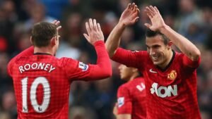 Wayne Rooney et Robin van Persie célébrant ensemble dans le maillot rouge emblématique de Manchester United lors d'un match de Premier League.