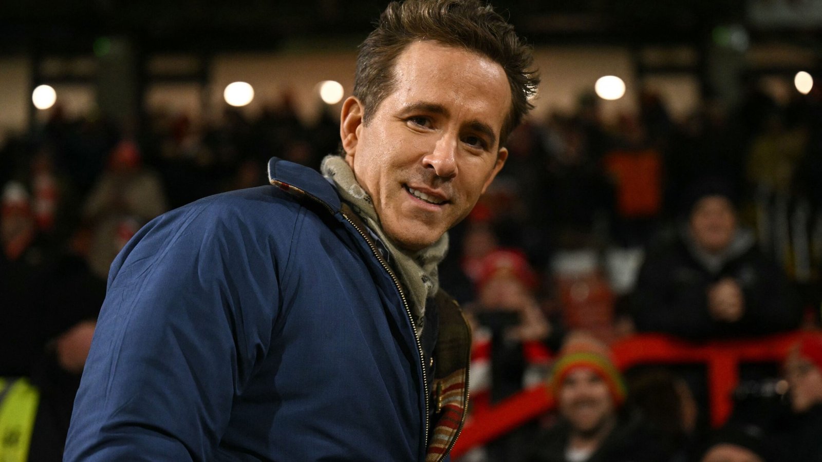 Ryan Reynolds sourit lors d'un match de Sheffield Wednesday, entouré de supporters enthousiastes dans le stade.