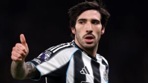 Sandro Tonali fait un geste de pouce levé, portant le maillot rayé noir et blanc de Newcastle United lors d'un match de Premier League.