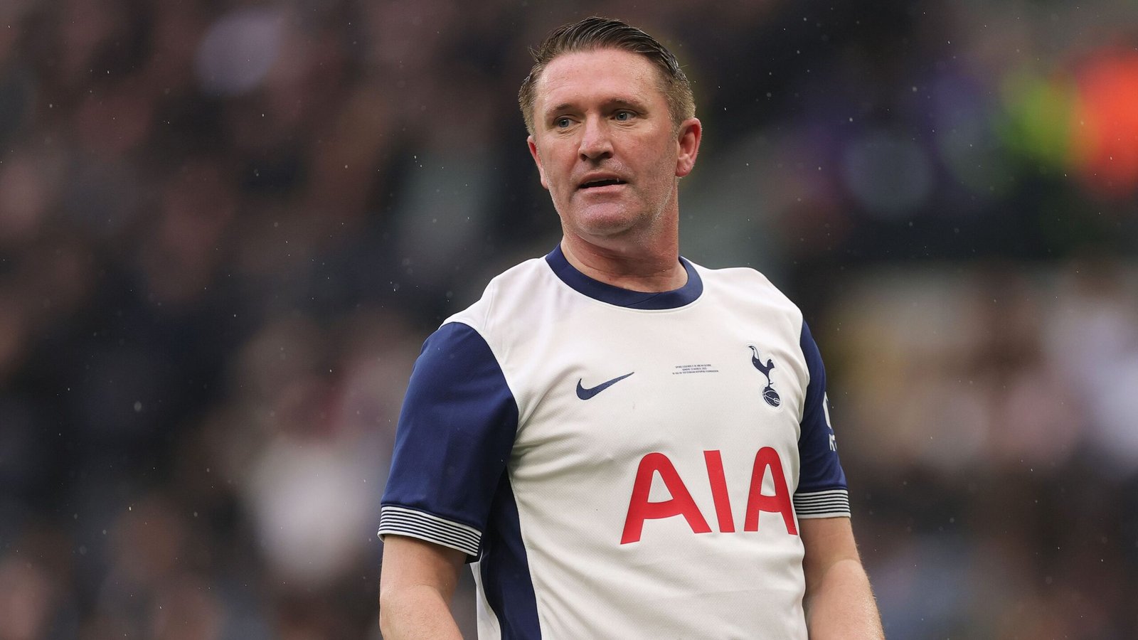 Robbie Keane in een Tottenham Hotspur-tenue, staand op het veld, toont de wit-navy kleuren van het team tijdens een wedstrijd.