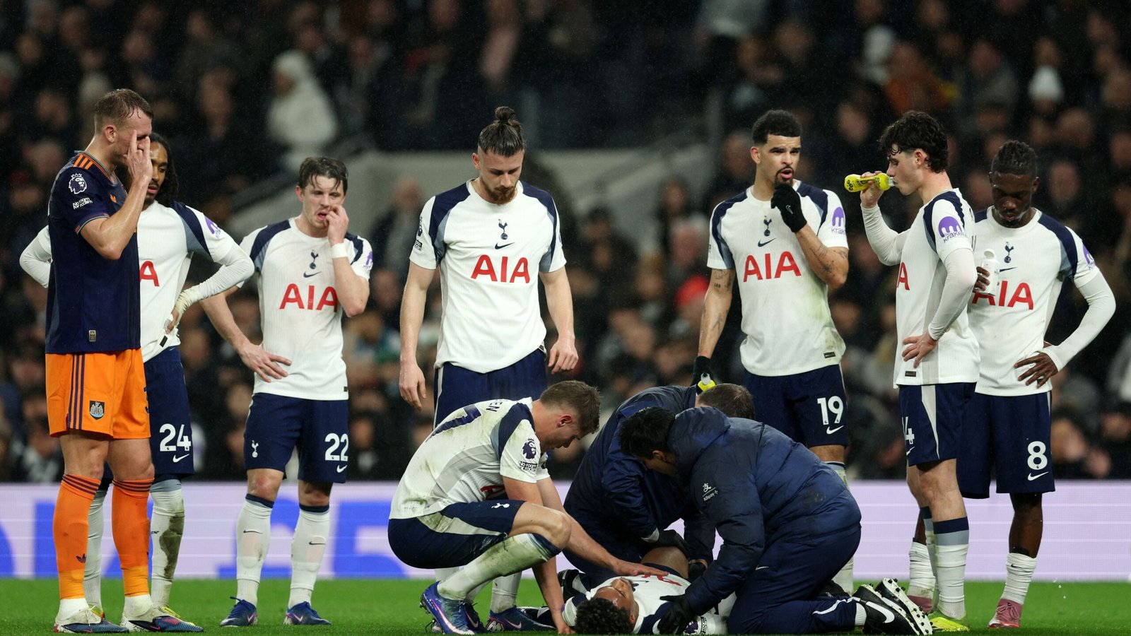 Les joueurs de Tottenham se rassemblent avec inquiétude autour d'un coéquipier recevant des soins médicaux sur le terrain pendant un match.