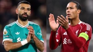 Mohammed Salah in een groenblauw tenue applaudisseert links, terwijl Virgil van Dijk in een rood Liverpool-tenue rechts klapt.