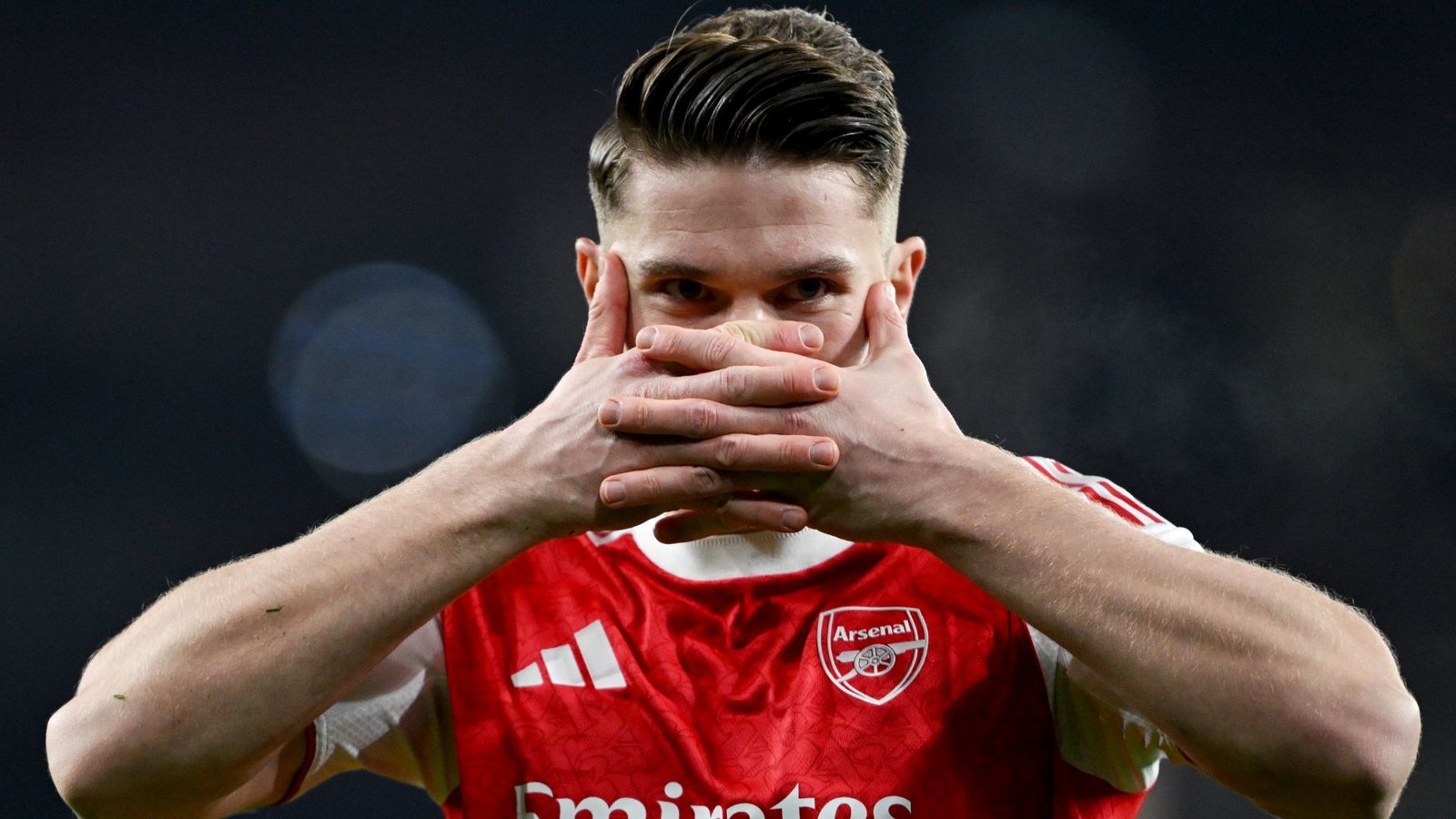 Viktor Gyökeres en tenue d'Arsenal, célébrant un but les mains sur le visage, illustrant l'esprit d'équipe et l'émotion.