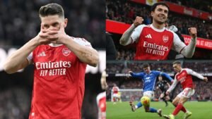 Arsenal-spelers vieren na een wedstrijd, waarbij Viktor Gyökeres tweemaal scoorde. Rode tenues domineren tussen stadionactie en fans.