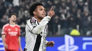 Weston McKennie celebrates after scoring for Juventus during a UEFA Champions League match against Benfica, wearing the team's black and white kit.