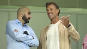 Walid Regragui en Hervé Renard delen een lachmoment, bespreken strategieën tijdens een wedstrijd, wat de kameraadschap in het Marokkaanse voetbal benadrukt.