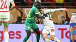 Morocco's player #10 engaged with a Senegalese defender wearing #5 during a tense moment in AFCON 2023 match action.