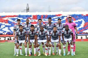 Moroccan football team lineup posing in front of a vibrant, colourful fan display, wearing unique, patterned jerseys for a cup match.