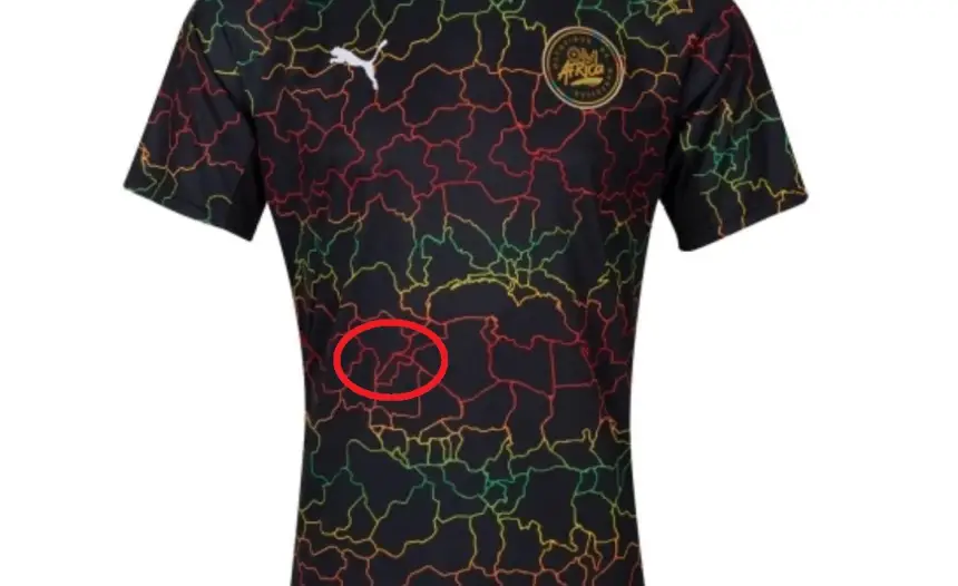 Marokkaans nationaal teamtenue met zwarte basis en kleurrijke geografische lijnen, benadrukt Afrikaanse wortels en eenheid.