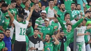 Raja Casablanca fans in green and white celebrate passionately in the stands, showcasing intense emotions after the match against Moghreb Tetouan.