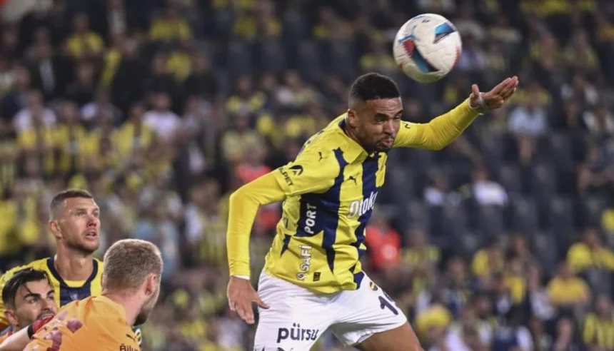Youssef En-Nesyri leaps to head the ball during a match, wearing a yellow and blue kit, with opposition players in the background.