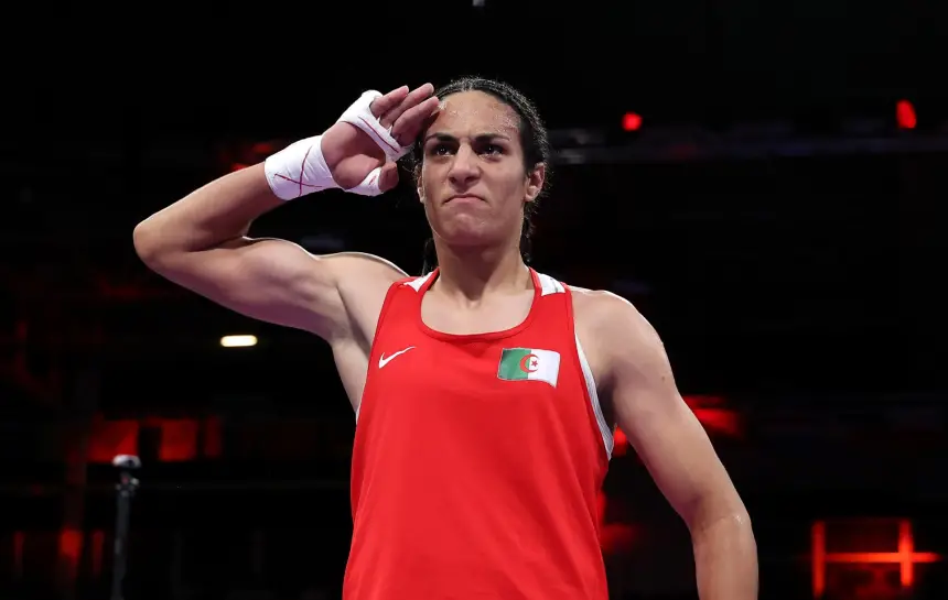 Moroccan boxer saluting in a red uniform with the national flag, showcasing strength and determination in a competitive stance.
