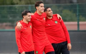 Marokkaanse nationale elftalspelers Achraf Hakimi, Yassine Bounou en Sofian Boufal glimlachen en vieren tijdens een trainingssessie.