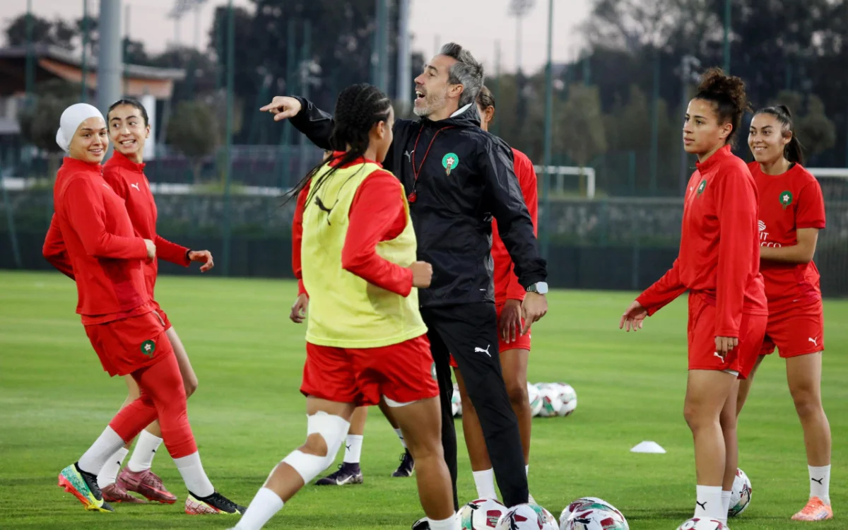 Moroccan women's football team training session, featuring players in red kits with a coach, showcasing teamwork and preparation for upcoming matches.