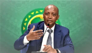 Ahmad Ahmad, CAF president, speaks passionately at a press conference, featuring a green backdrop with the African map and stars.