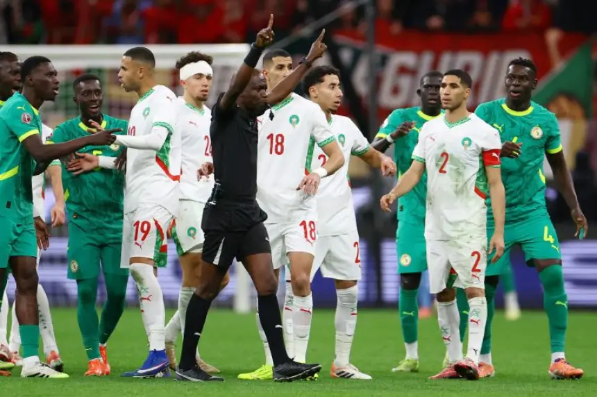 Marokkaanse spelers in witte tenues confronteren de scheidsrechter tijdens een gespannen moment tegen Senegal in een WK-kwalificatiewedstrijd.