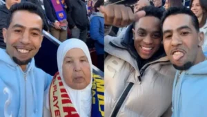 Two Moroccan fans at a football match, one wearing a Barcelona scarf, smiling and posing together with a woman in a headscarf.